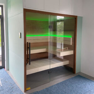 Sauna mit Glasfront mit grünen Lichtelementen